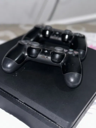 PlayStation 4 with two controllers and two games